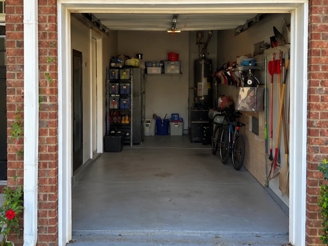 After: the same garage with a clear swept floor, bins on the shelves, bikes and tools along the wall