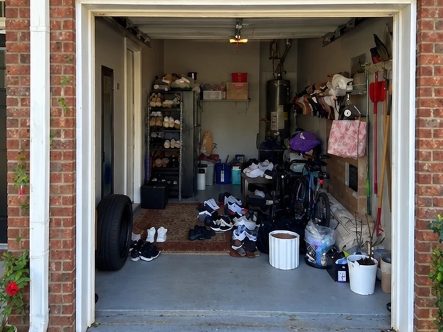 Before: a one-car garage with shoes, a tire, a rug, bags and a bike covering the floor